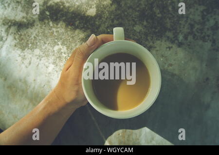 Le matin, une tasse de café en main, vintage la nuance de couleur. Banque D'Images