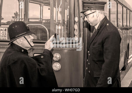 Le gendarme de la police britannique admonishing chauffeur de bus; Morecambe historique événements de bord de mer; années 1930, années 1940, années 1950, festival de mode rétro Vintage by the Sea, personnes en costume, réacteurs en costumes d'époque, vêtements authentiques d'époque, costume de guerre fantaisie, costumes historiques, vêtements de reconstitution, Royaume-Uni Banque D'Images