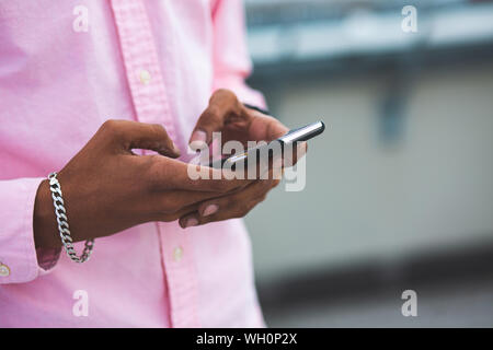 Close up of Black Afro-américain Man working with Smartphone Banque D'Images