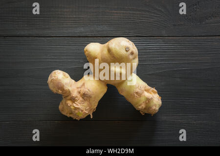 Bio pommes anormale laid sur planche de bois noir. Concept des légumes biologiques. Vue d'en haut. Banque D'Images