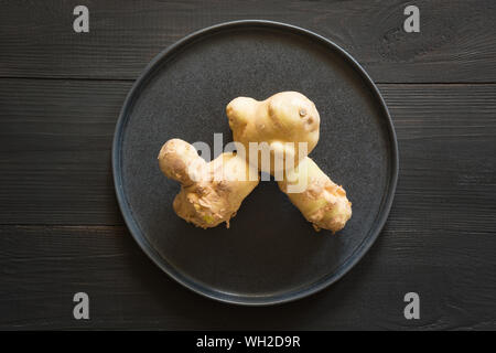 Bio pommes anormale laid sur planche de bois noir. Concept des légumes biologiques. Vue d'en haut. Banque D'Images