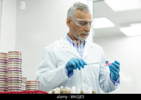 Heureux travailleur médical faisant des recherches en microbiologie Banque D'Images