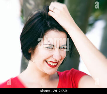 Young woman smiling nonchalamment entre les arbres dans un parc-SAN SEBASTIAN-ESPAGNE-europe Banque D'Images