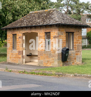 L'ironstone Smart abri bus avec toit en ardoise Collyweston dans le village de Lyddington, Rutland, England, UK Banque D'Images