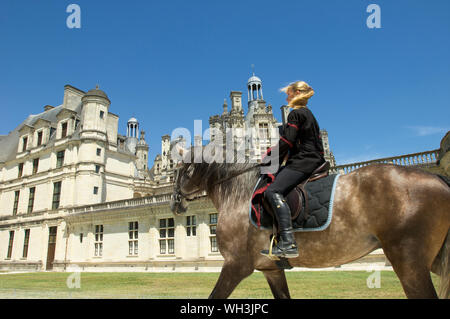 Fille sur un cheval passant le château de Chambord à Blois dans la vallée de la Loire, France Banque D'Images