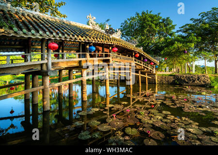 Thanh Toan tile pont. Vieux pont en bois traverse la rivière branch décoré d'un toit de tuile supérieure datant du 19e siècle. Hue, Vietnam Banque D'Images