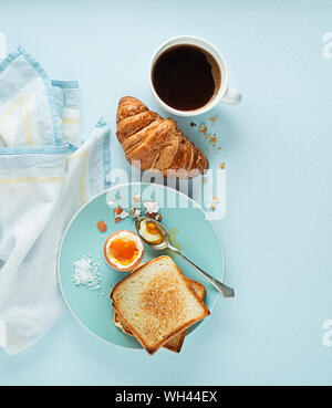 Petit-déjeuner servi avec croissants, café, oeuf mollet et toasts. Table de petit-déjeuner continental Banque D'Images