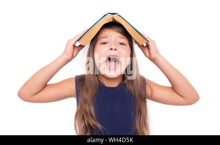 Petite fille avec un livre ouvert sur sa tête est en colère. Banque D'Images