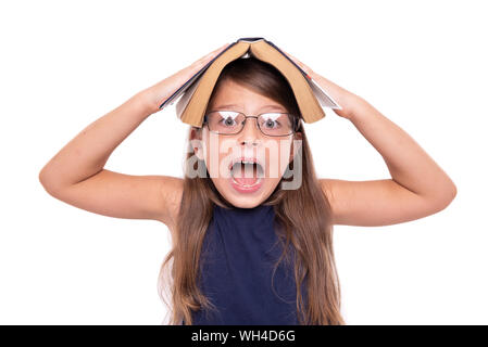 Petite fille avec un livre ouvert sur sa tête est en colère. Banque D'Images