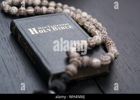 Old Holy Bible et chapelet sur table rustique Banque D'Images