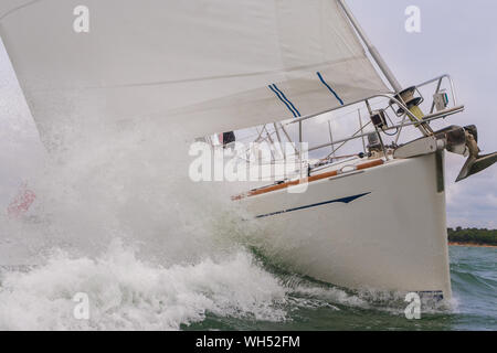 Close up de bateau à voile, voilier ou yacht s'écraser à travers les vagues dans une mer agitée Banque D'Images