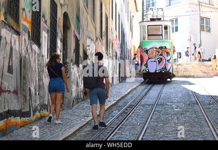 Les touristes à monter la pente raide de la rue pavée Rua Da Gloria avec son célèbre cable car connu sous le nom de l'ascensor da Glória Elvador ou dans l'arrière-plan Banque D'Images