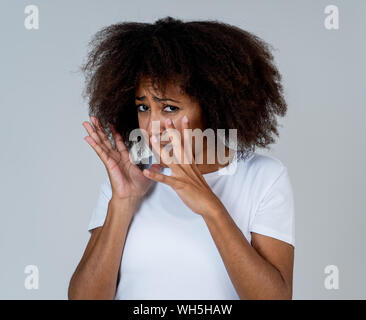 Portrait of young african american woman sentiment effrayé et choqué de faire peur, d'anxiété de gestes. Terrifié à la couvrant elle-même. Copier l'espace. Dans Banque D'Images