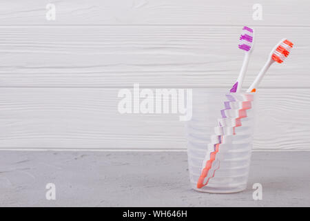 Brosses à dents colorées en verre sur fond de bois. Banque D'Images