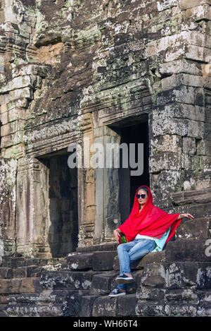 Une jeune femme asiatique pose pour une photo sur les marches du temple Bayon à Siem Reap, Cambodge Banque D'Images