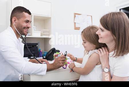 Médecin pédiatrie positive tout en travaillant avec un enfant. mère avec un enfant examiné par un pédiatre Banque D'Images