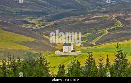 CORGARFF CASTLE ABERDEENSHIRE ECOSSE LE BÂTIMENT BLANC VU DU LECHT ROAD AVEC PURPLE HEATHER SUR LES COLLINES À LA FIN DE L'ÉTÉ Banque D'Images