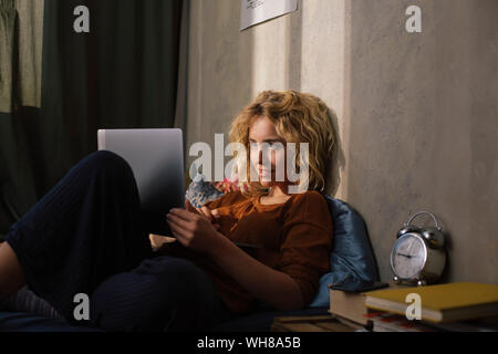 Portrait of young blonde woman using laptop Banque D'Images