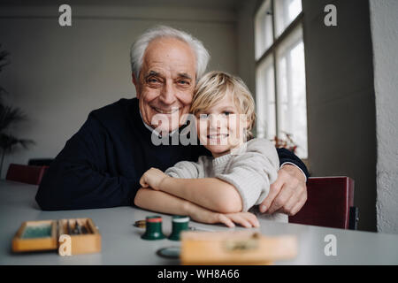 Portrait of happy horloger et son petit-fils assis à table Banque D'Images