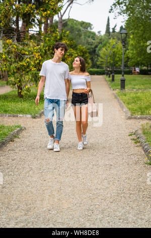 Jeune couple en train de marcher ensemble dans un parc Banque D'Images