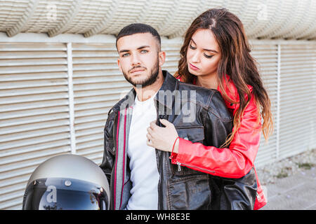 Portrait de couple avec casque de moto portant des blousons de cuir Banque D'Images