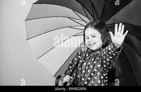 Petite fille en imperméable. automne fashion hipster joyeux. enfant dans l'humeur positive. protection contre la pluie. Arc-en-ciel. Heureux petite fille avec parapluie colorés. Belle désinvolture. Banque D'Images