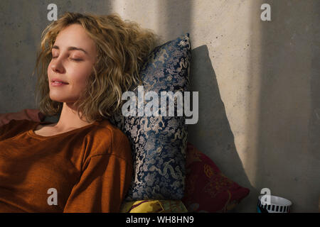 Portrait of young woman relaxing on bed Banque D'Images