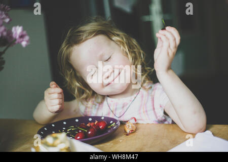 Portrait de petite fille profiter de cerises Banque D'Images