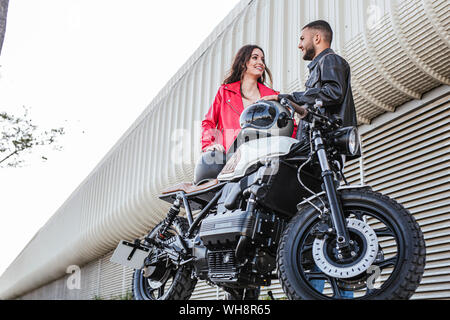 Avec deux casques de moto debout à côté de moto Banque D'Images