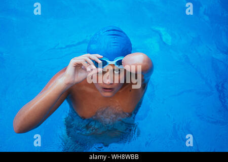 Portrait de jeune nageuse paralympique de mettre des lunettes swimmming Banque D'Images