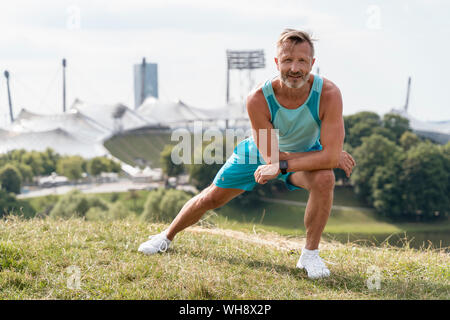 L'homme sportif qui s'étend dans un parc Banque D'Images