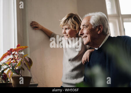 Grand-père et son petit-fils à la maison à la fenêtre de Banque D'Images