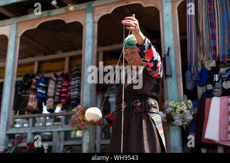 Une femme sherpa de Gosainkund bébé tourne la laine de Yak en utilisant la méthode traditionnelle avec une broche, Langtang région, Népal, Asie Banque D'Images