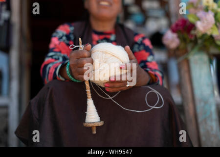 Une femme sherpa de Gosainkund bébé tourne la laine de Yak en utilisant la méthode traditionnelle avec une broche, Langtang région, Népal, Asie Banque D'Images