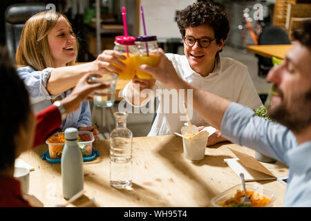 Office having lunch break clinking glasses Banque D'Images