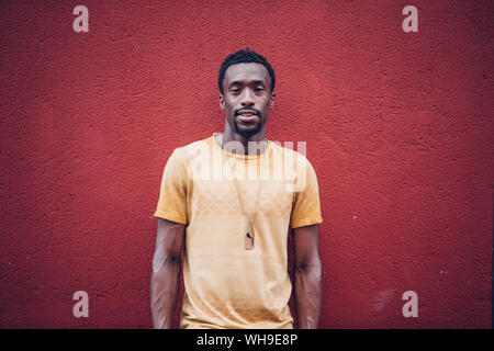 Portrait de jeune homme barbu en face de red wall Banque D'Images