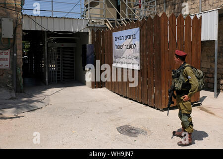 Un soldat israélien armé de la Brigade de 35th, également connu sous le nom de Brigade des parachutistes, tient la garde à Bab El-Zawiya traversant le quartier palestinien de Bab a-Zawiya et de la zone de contrôle israélienne H-2 dans la ville divisée d'Hébron en Cisjordanie Israël Banque D'Images