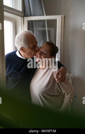 Happy senior couple à la fenêtre à la maison Banque D'Images