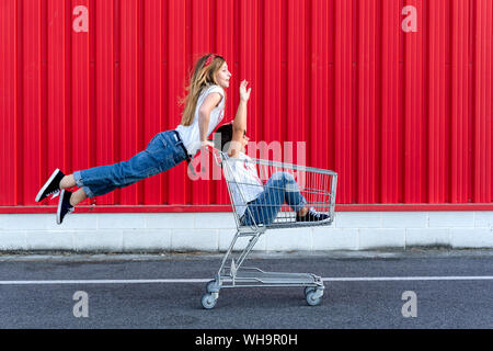 Les sœurs avec panier en face de red wall Banque D'Images