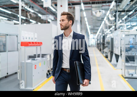 Businessman walking dans une usine moderne Banque D'Images