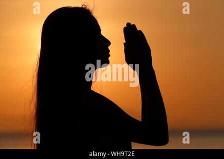Silhouette d'une femme debout près de la mer au coucher du soleil le yoga et la méditation, pose du PES, Cambodge, Indochine, Asie du Sud-Est, l'Asie Banque D'Images