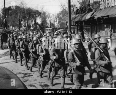 WW2 : la victoire bombardé Mars à Shanghai. Les troupes japonaises marchant au-delà d'un poste dans la région de Jessfield. Les soldats japonais ont été attaqué par un chinois qui ont lancé une grenade au milieu d'eux mais les Chinois a été tué. Banque D'Images