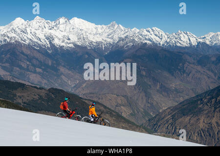 Vélo de montagne sur une pente couverte de neige dans l'Himalaya avec vue sur le langtang montagne dans la distance, Népal, Asie Banque D'Images