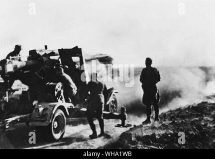 WW2 : allemand canon anti-aérien en action contre la Marsa el Brega près de réservoirs. Banque D'Images