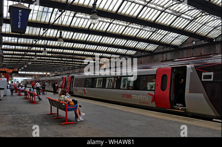 Un train de cross-country se situe à Stoke on Trent gare la formation d'un service à Bournemouth, passagers ou du conseil d'attendre leur train. Banque D'Images