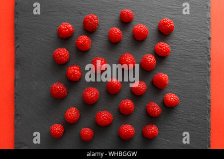 Vue de dessus de framboises rouges sur une plaque tableau noir Banque D'Images