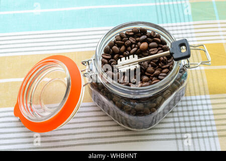 Dans un grand bol en verre clip top avec les grains de café sur une nappe. Pour les produits alimentaires en vrac peut comme cache ou coffre-fort. Quelque chose à cacher. La clé dans un bocal. Banque D'Images