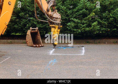 Travailleur de la construction réparation route avec digger exploitation Jackhammer Banque D'Images