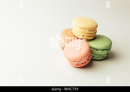 Macarons colorés frais se situent dans un tas de côté. Meringue sur un fond isolé with copy space Banque D'Images