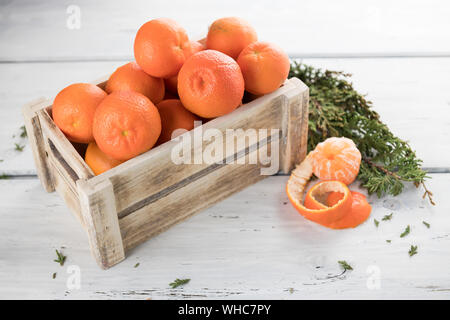 Mûre juteuse mandarine italienne o les clémentines dans une boîte en bois sur fond blanc Banque D'Images